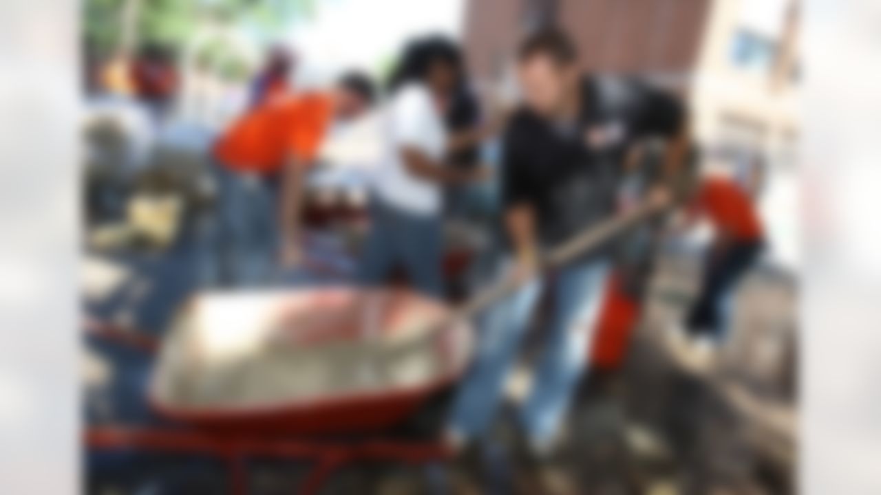 Mike Furrey, David Rock (The Home Depot) and Claudia Logan (Joy Prep) getting their hands dirty as they mix concrete for the new playground. (Photo by Tom Copeland/Home Depot)