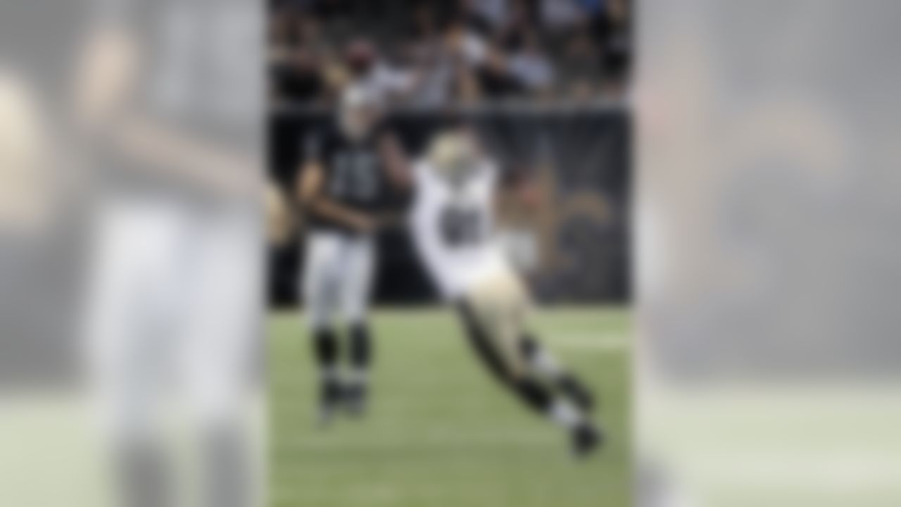 New Orleans Saints linebacker Will Smith (91) tries to block a pass by Oakland Raiders quarterback Matt Flynn (15) during the first half of an NFL preseason football game at the Mercedes-Benz Superdome in New Orleans, Friday, Aug. 16, 2013. (AP Photo/Matthew Hinton)