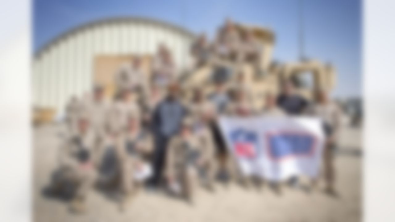 Continuing a time honored USO/NFL tradition, Brandon Fields of the Miami Dolphins, Pierre Garcon of the Washington Redskins and Jimmy Graham of the New Orleans Saints pose for a group of troops stationed in the Middle East on March 4, 2014. This is the trio's first USO/NFL tour. (USO Photo by Dave Gatley)