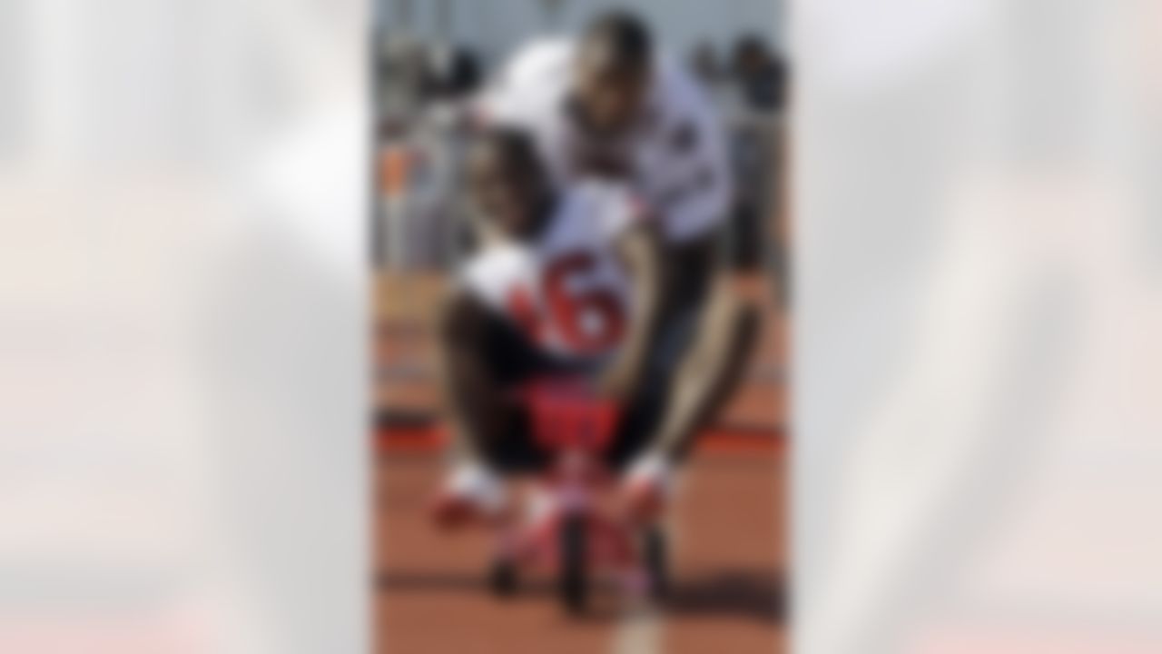 Houston Texans rookie wide receiver Trindon Holliday (16) is pushed on a kid tricycle by veteran wide receiver Jacoby Jones, top, after a NFL football training camp practice Wednesday, Aug. 4, 2010 in Houston. (AP Photo/David J. Phillip)