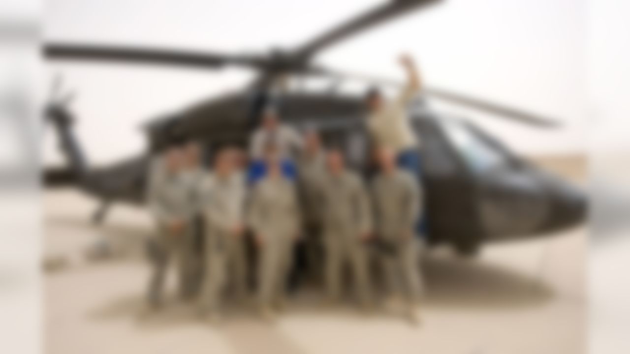 The NFL touring party was provided with dedicated air support in the form of Balckhawk helicopters to safely transit these large distances over a relatively dangerous area. Posing for a photo with a flight crew, the tour participants extended their gratitude for the air lift and support for their military service.  (USO photo by Dave Gatley)