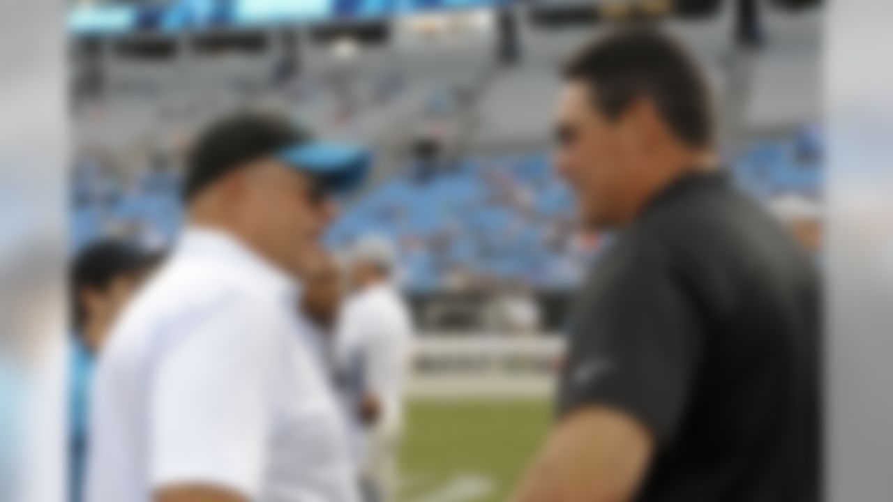 Carolina Panthers owner David Tepper, left, talks with head coach Ron Rivera, right, before a preseason NFL football game against the Miami Dolphins in Charlotte, N.C., Friday, Aug. 17, 2018. (AP Photo/Mike McCarn)