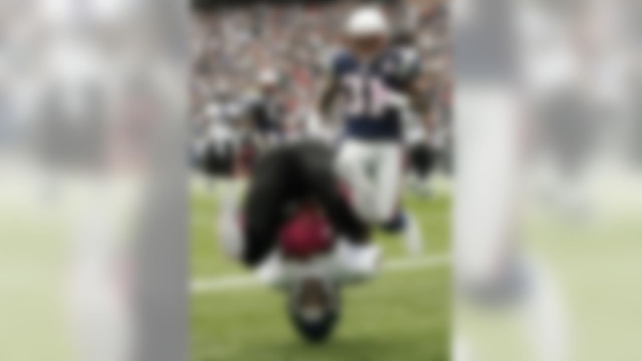 Baltimore Ravens wide receiver Derrick Mason, foreground, lands on his head after catching a touchdown pass as New England Patriots safety Brandon Meriweather (31) looks on during the first quarter of an NFL football game Sunday, Oct. 4, 2009, in Foxborough, Mass. (AP Photo/Winslow Townson)