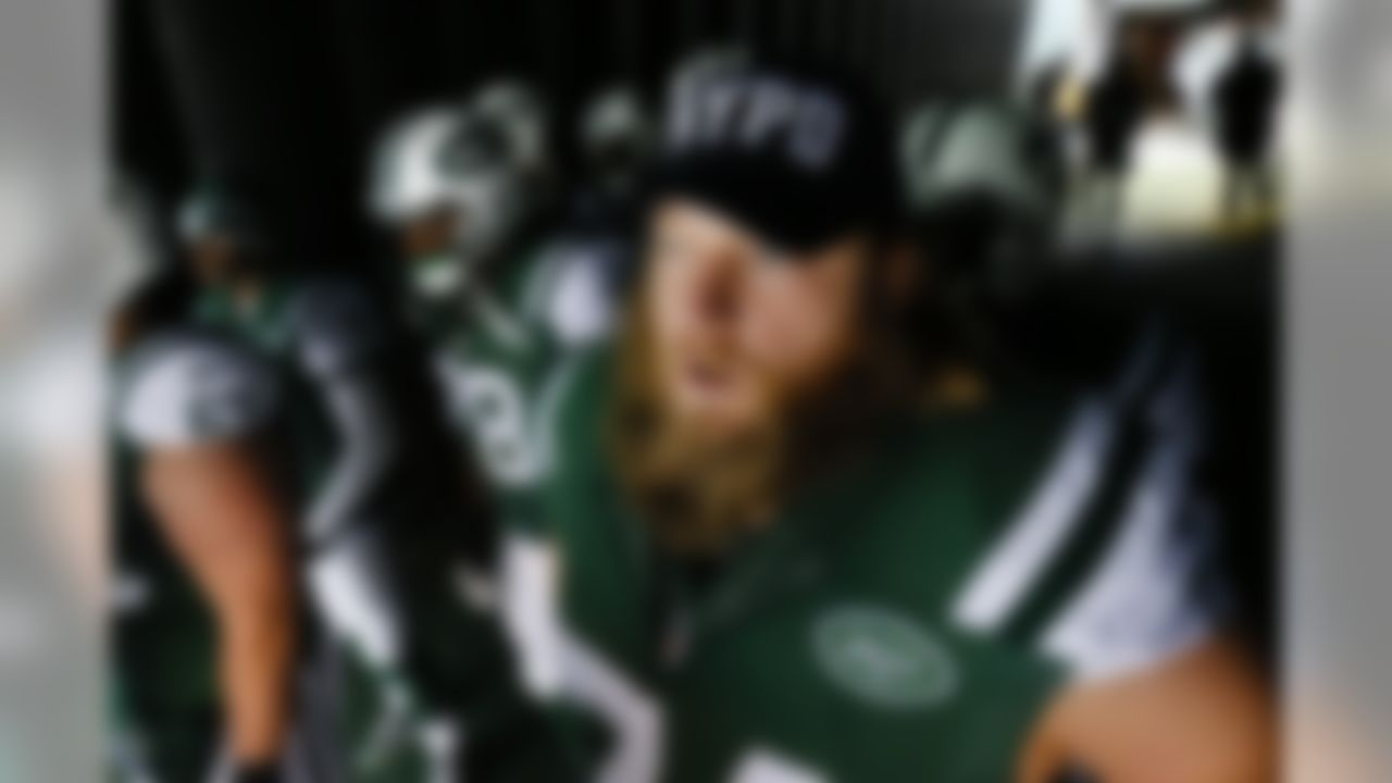 New York Jets center Nick Mangold (74) wears an NYPD hat as he waits to go on the field for the start of an NFL football game against the New England Patriots, Sunday, Dec. 21, 2014, in East Rutherford, N.J. (AP Photo/Julio Cortez)