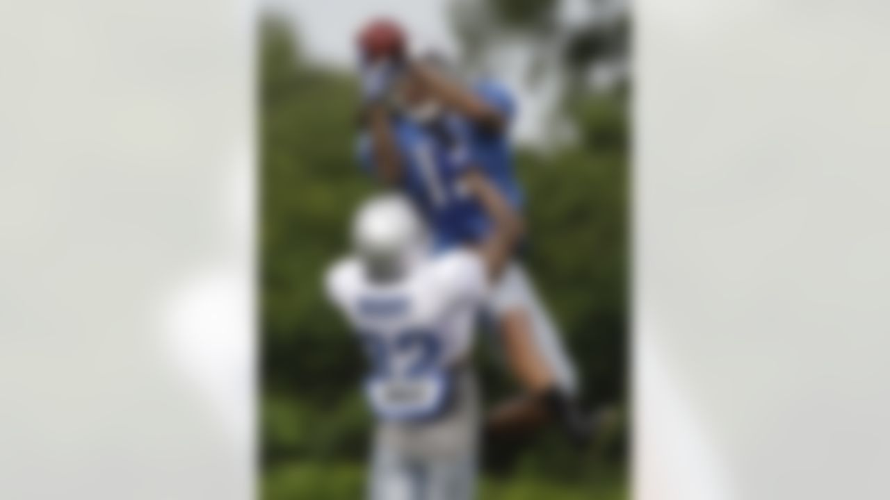 Detroit Lions receiver Michael Moore catches a pass while defended by cornerback Aaron Berry (32) during drills  at NFL football training camp in Allen Park, Mich., Tuesday, Aug. 2, 2011. (AP Photo/Carlos Osorio)