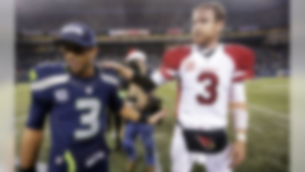 Arizona Cardinals quarterback Carson Palmer, right, greets Seattle Seahawks quarterback Russell Wilson after an NFL football game, Sunday, Dec. 22, 2013, in Seattle. Arizona won 17-10. (AP Photo/Elaine Thompson)