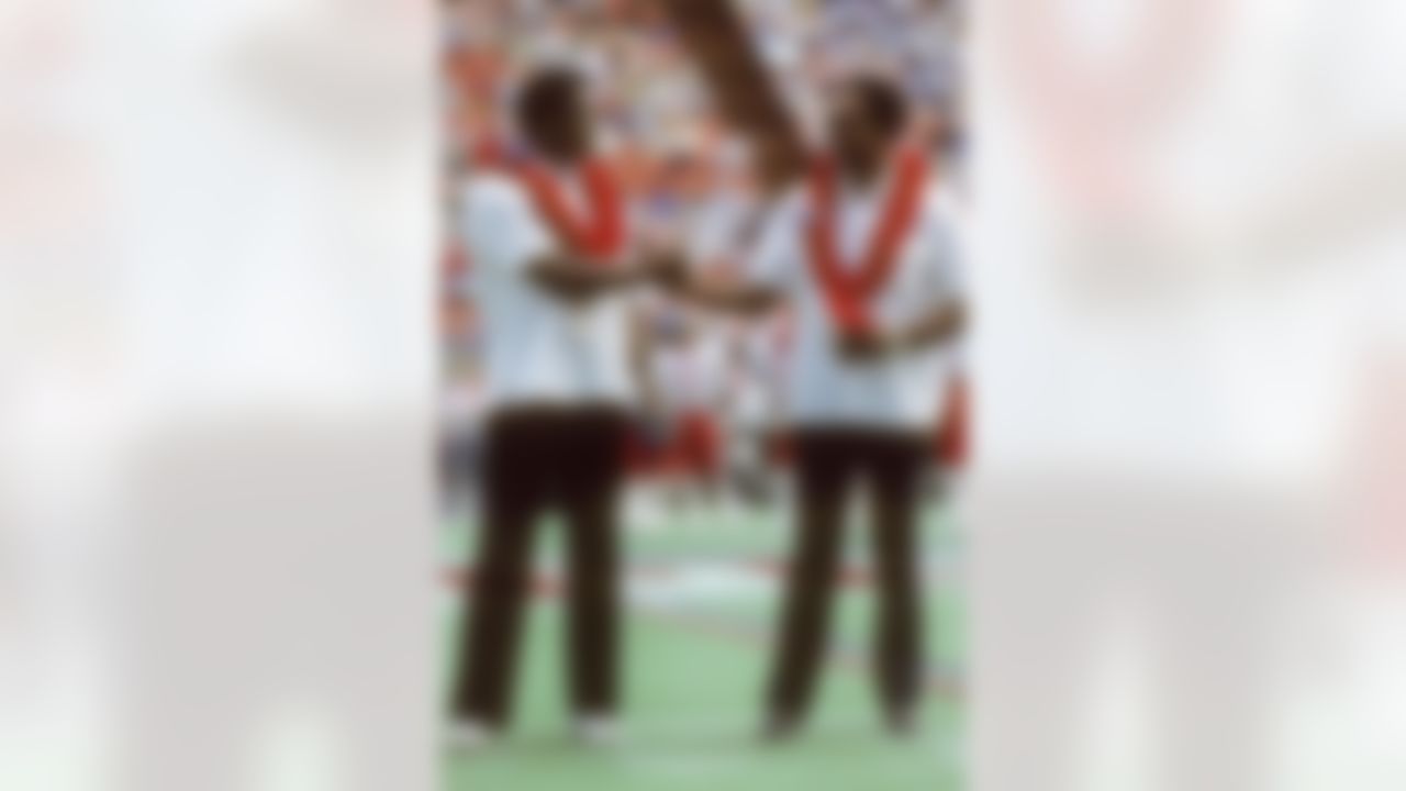 Newly announced members of the Pro Football Hall of Fame (L-R) and former Washington Redskins wide receiver Charley Taylor shakes hands with Oakland Raiders cornerback Willie Brown as they are introduced to fans during the NFL Pro Bowl football game between the AFC and the NFC in Honolulu, Hawaii on January 29, 1984. The NFC won the game 45-3. (AP Photo/Paul Spinelli)