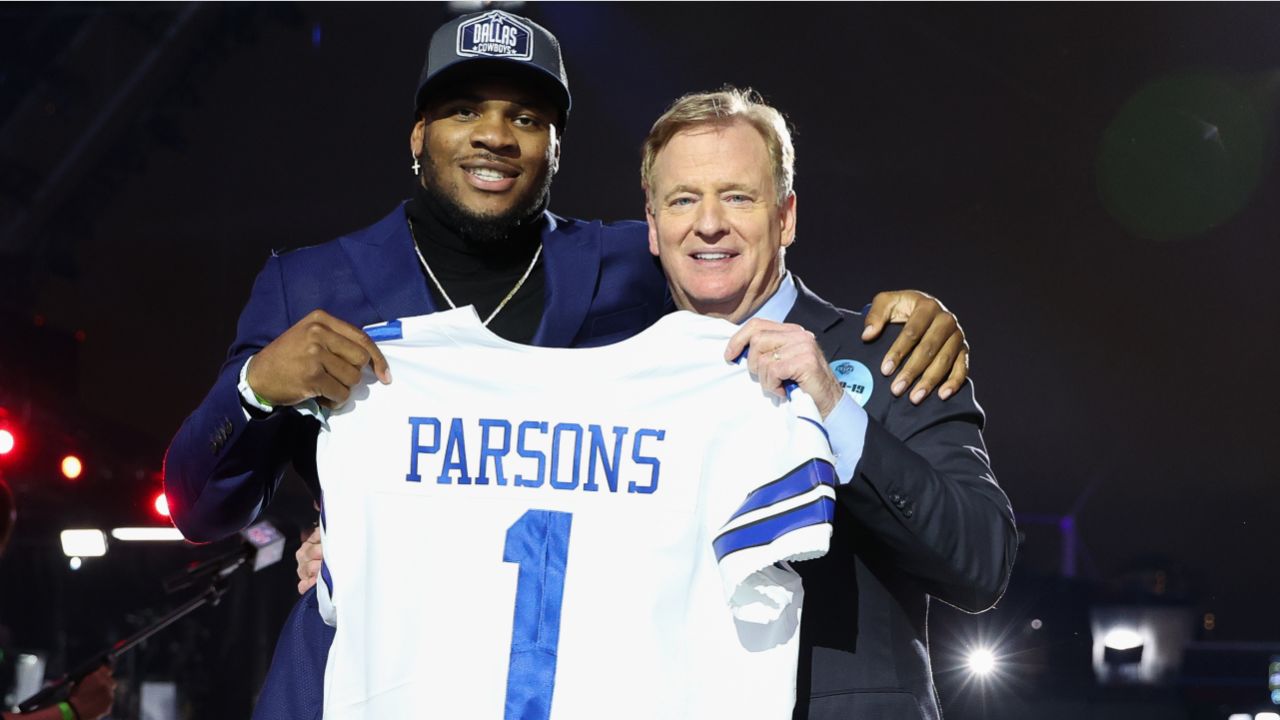 Penn State linebacker Micah Parsons, right, holds a team jersey with NFL  Commissioner Roger Goodell after the was chosen by the Dallas Cowboys with  the 12th pick in the NFL football draft