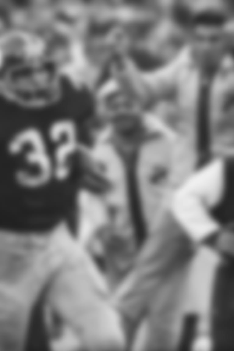 FILE - In this Dec. 23, 1972, file photo, Pittsburgh Steelers' Franco Harris (32) eludes a tackle by Oakland Raiders' Jimmy Warren as he runs 42-yards for a touchdown after catching a deflected pass during an AFC Divisional NFL football playoff game in Pittsburgh. Harris' scoop of a deflected pass and subsequent run for the winning touchdown, forever known as the "Immaculate Reception." (AP Photo/Harry Cabluck, File)