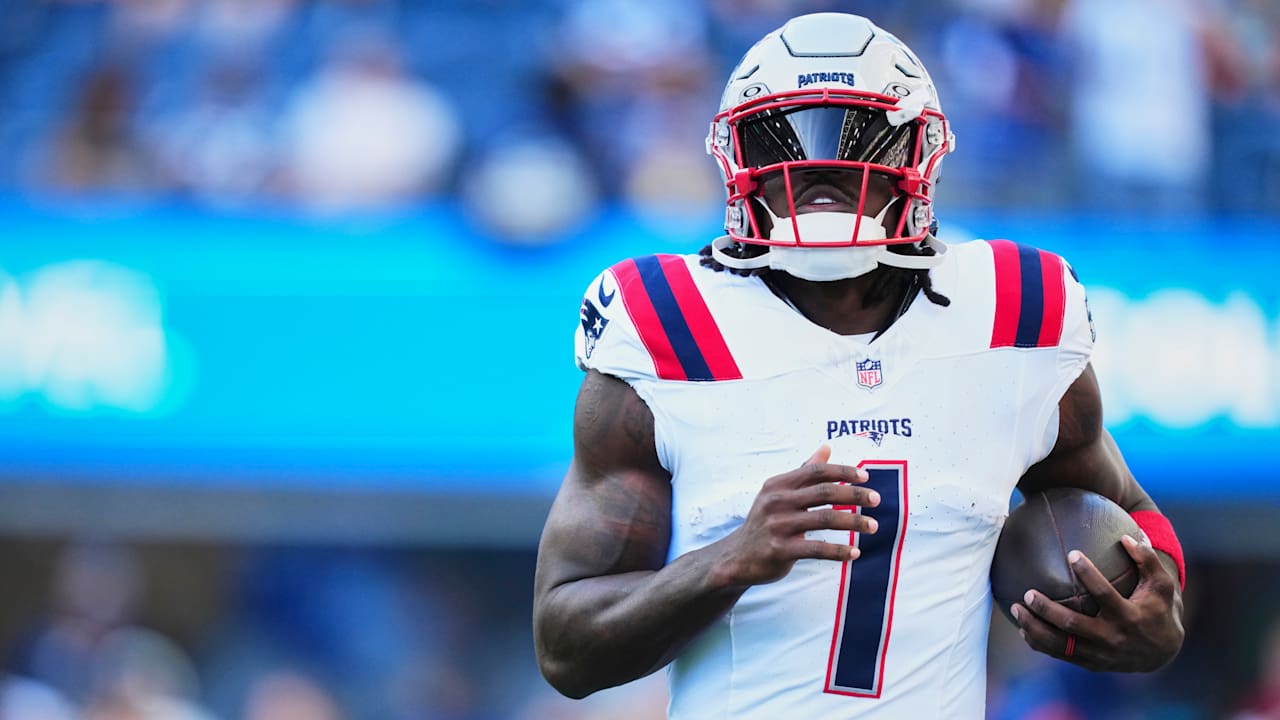 A.J. Brown in a white Patriots uniform, holding a football