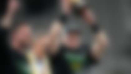 Oregon quarterback Bo Nix, right, holds up the offensive MVP trophy after Oregon defeated Liberty in the Fiesta Bowl NCAA college football game as Oregon head coach Dan Lanning, left, looks on Monday, Jan. 1, 2024, in Glendale, Ariz. Oregon won 45-6. (AP Photo/Ross D. Franklin)