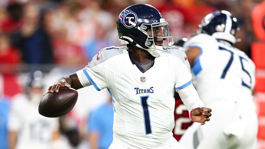 Titans quarterback number 1 holds the football while scanning the field during a game.