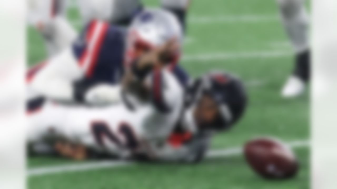 Houston Texans running back Woody Marks, bottom, looks toward the ball after fumbling, which was recovered by the New England Patriots, during the second half of an NFL divisional playoff football game, Sunday, Jan. 18, 2026, in Foxborough, Mass.