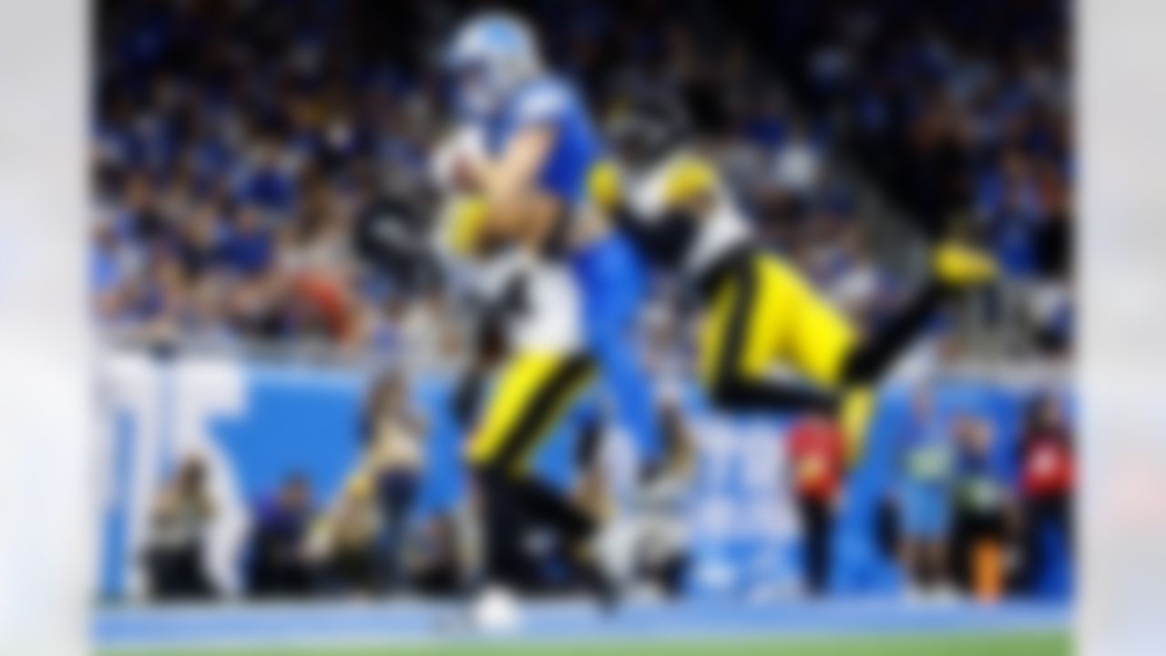 Detroit Lions' Isaac Teslaa scores a touchdown between Pittsburgh Steelers' Kyle Dugger, left, and Chuck Clark during the first half of an NFL football game, Sunday, Dec. 21, 2025, in Detroit.