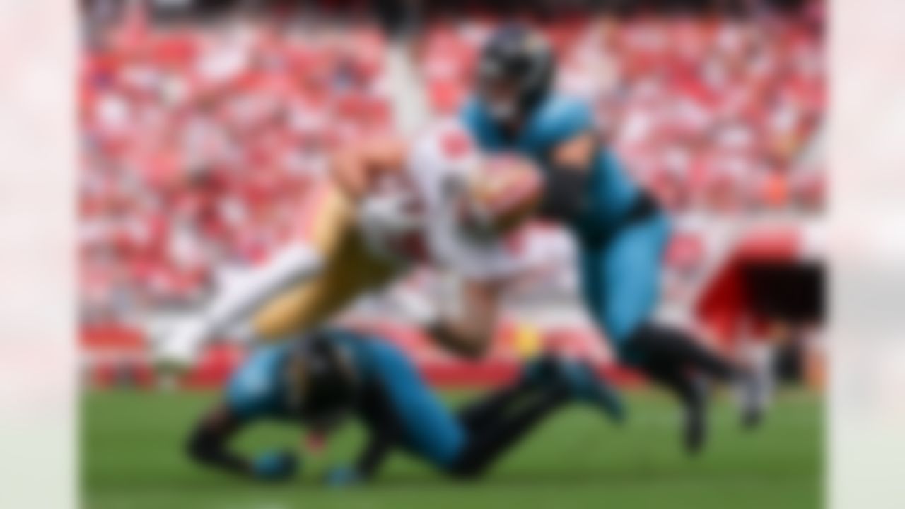 Jacksonville Jaguars wide receiver Travis Hunter (12) and safety Andrew Wingard (42) tackles San Francisco 49ers tight end Luke Farrell (89) during an NFL football game on Sunday, September 28, 2025 in Santa Clara, California.