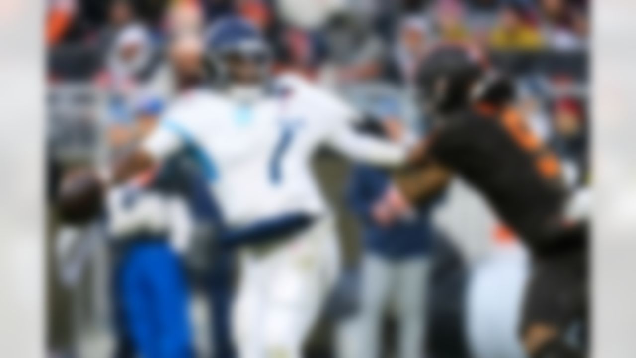 Tennessee Titans quarterback Cam Ward (1) fights off a tackle attempt by Cleveland Browns safety Grant Delpit (9) in the second half of an NFL football game in Cleveland, Sunday, Dec. 7, 2025.