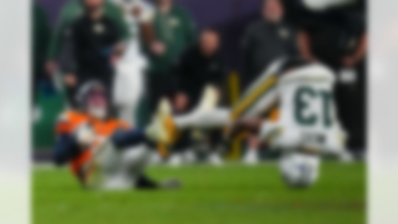 Denver Broncos cornerback Riley Moss (21) intercepts a pass against Green Bay Packers wide receiver Dontayvion Wicks (13) during an NFL football game, Sunday, Dec. 14, 2025, in Denver.